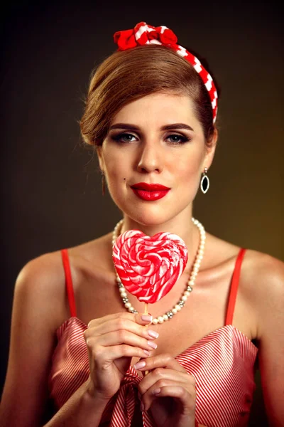 Woman eating lollipops. Girl in pin-up style hold striped candy. — Stock Photo, Image
