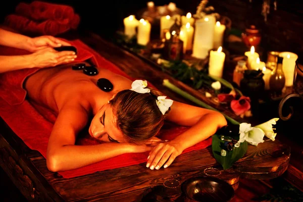 Massage stenen van vrouw in spa salon. Meisje kaarsen achtergrond. — Stockfoto