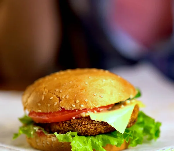 Hamburguesa de comida rápida con jamón sobre tabla de madera. Fondo borroso . — Foto de Stock