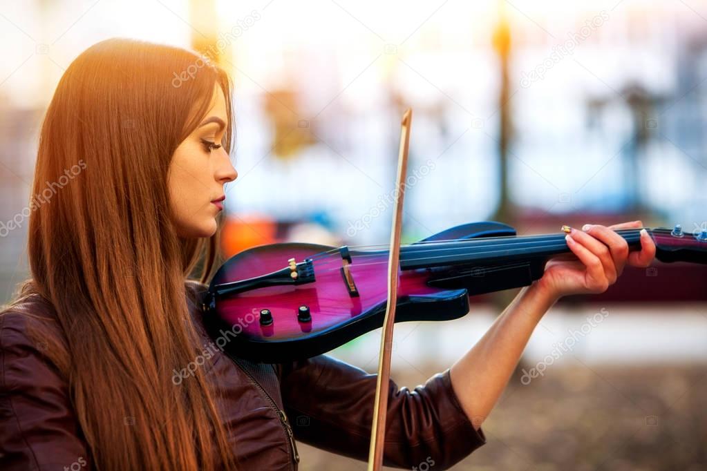 Busker woman perform music on violin park outdoor. Girl performing .