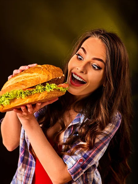 Woman eating hamburger. Girl bite of very big burger