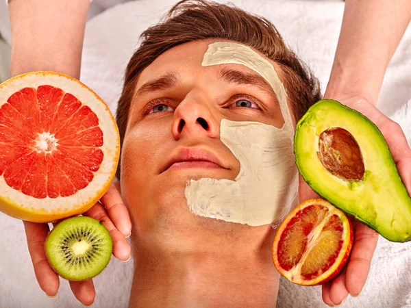 Facial mask from fresh fruits for man . Beautician apply slices. — Stock Photo, Image