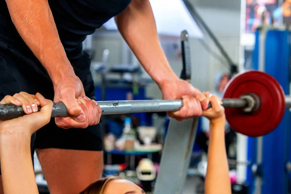 Fitnessfreunde trainieren Fitnessstudio. Frau arbeitet am Bankdrücken. — Stockfoto