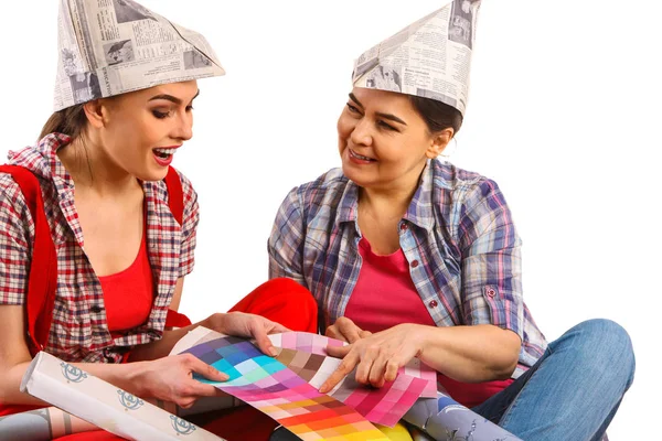 Repair home women holding color guide for wallpaper. — Stock Photo, Image