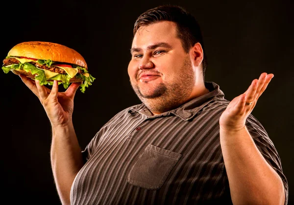 Hombre gordo comiendo hamburguesa de comida rápida. Desayuno para personas con sobrepeso . — Foto de Stock