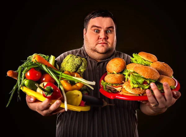 Dieta homem gordo faz escolha entre alimentos saudáveis e não saudáveis . — Fotografia de Stock