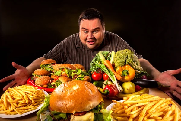 Dieta grasso uomo fa la scelta tra cibo sano e malsano . — Foto Stock