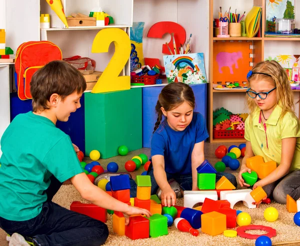 Niños jugando en cubos de niños en interiores. Lección en escuela primaria . —  Fotos de Stock