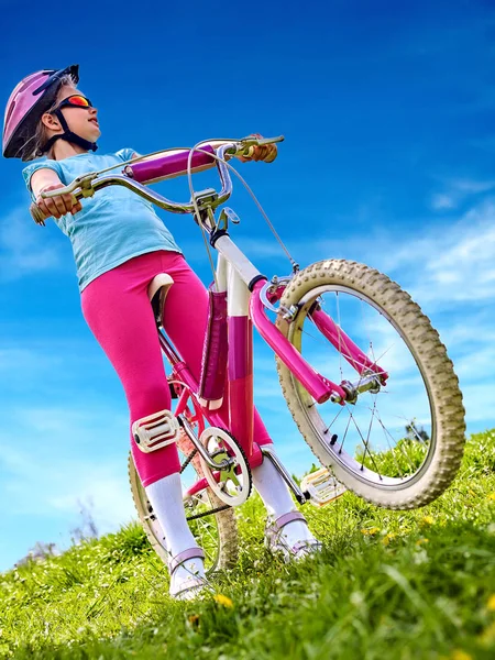 Frau mit Fahrrad auf grünem Gras im Sommerpark unterwegs. — Stockfoto