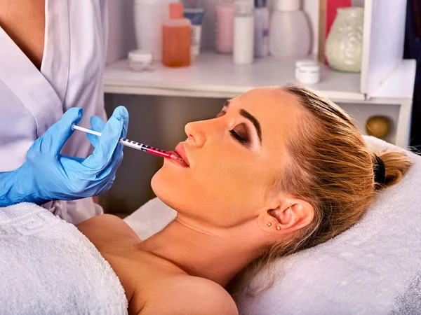 Dermal fillers lips of woman in spa salon with beautician.