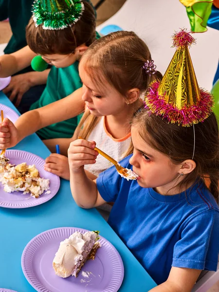 As crianças de aniversário celebram a festa e comem bolo no prato juntos  . — Fotografia de Stock