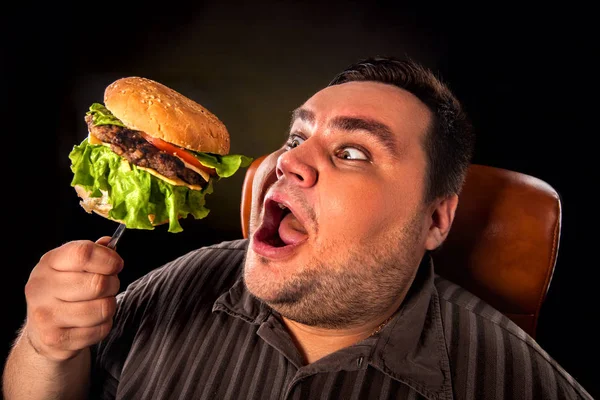 Fat man eating fast food hamberger. Breakfast for overweight person. Stock Picture