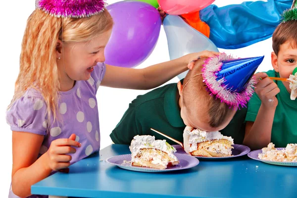 As crianças de aniversário celebram a festa e comem bolo no prato juntos  . — Fotografia de Stock