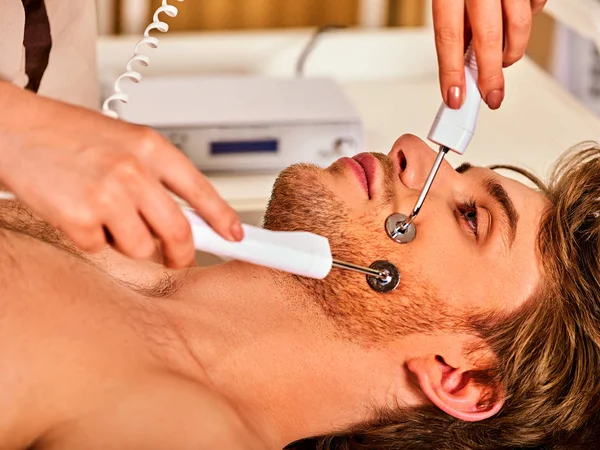Ansiktsmassage på skönhetssalongen. Elektrisk stimulering kvinna hudvård. — Stockfoto