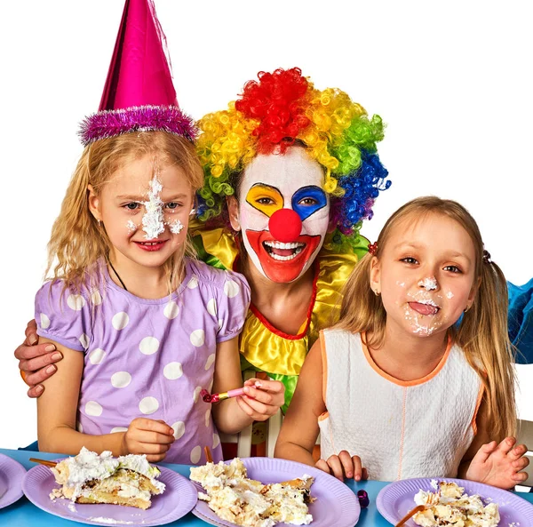 Narozeniny děti klaun společně jíst dort s chlapcem. Kluk s chaotický obličeje. — Stock fotografie