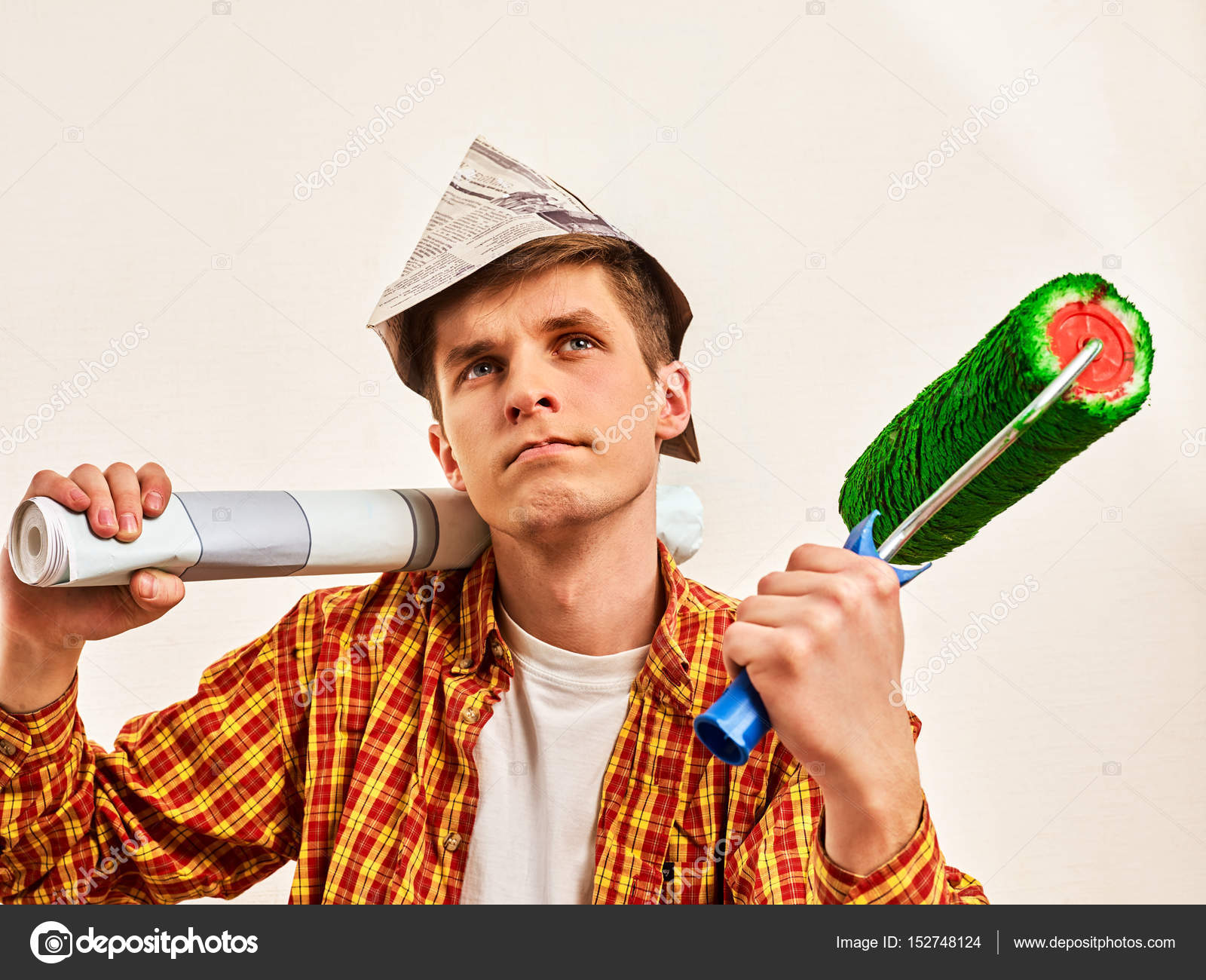 ホームを抱きかかえた壁紙用ペンキ ローラーを修復します ストック写真 C Poznyakov