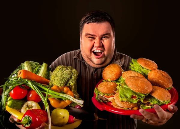 Diyet şişman adam sağlıklı ve sağlıksız gıda arasında seçim yapar. — Stok fotoğraf