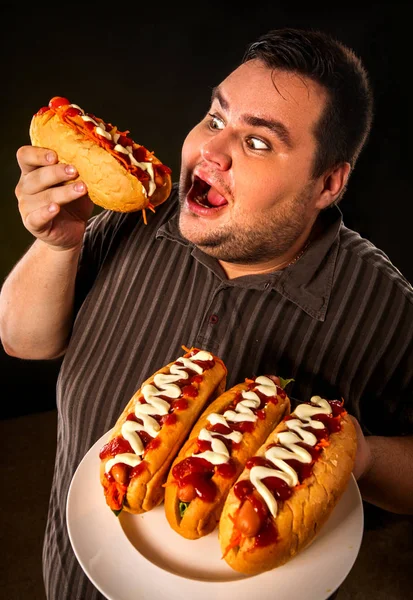 Şişman adam yemek lokanta sosisli sandviç. Kilolu kişi için kahvaltı. — Stok fotoğraf
