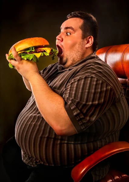 Hombre gordo comiendo hamburguesa de comida rápida. Desayuno para personas con sobrepeso . — Foto de Stock