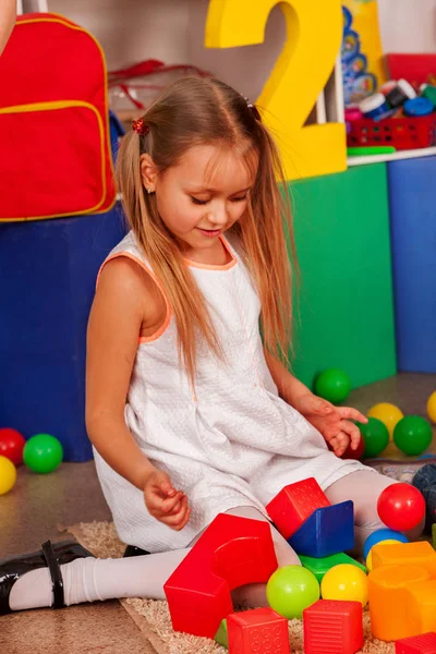 Bambino che gioca in cubi per bambini al coperto. Rompere la scuola dei bambini  . — Foto Stock
