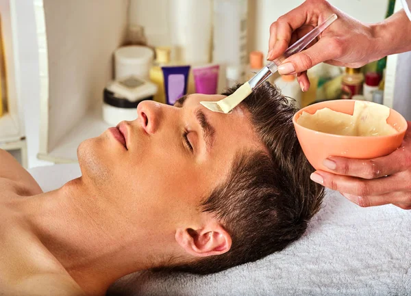 Máscara facial de barro de la mujer en el salón de spa. Masaje facial  . — Foto de Stock