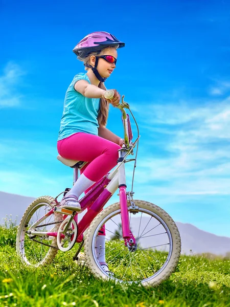 Barn reser cykel i rainbow glasögon och hjälm i park. — Stockfoto