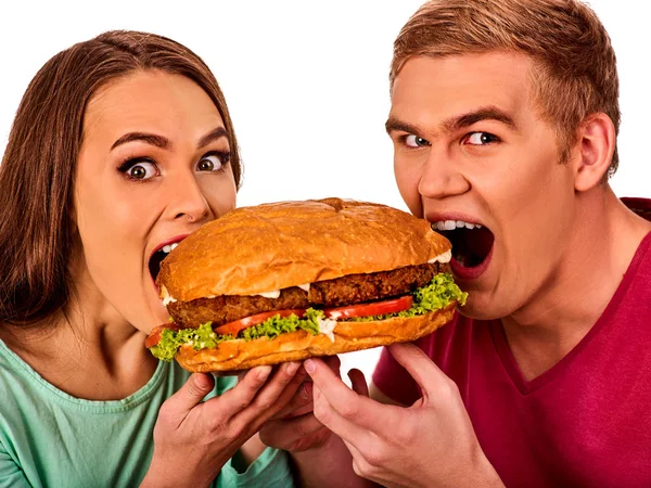 Casal a comer fast food. Homem e mulher tratam hambúrguer  . — Fotografia de Stock