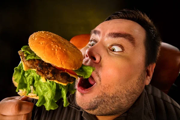 Hombre gordo comiendo hamburguesa de comida rápida. Desayuno para personas con sobrepeso . —  Fotos de Stock