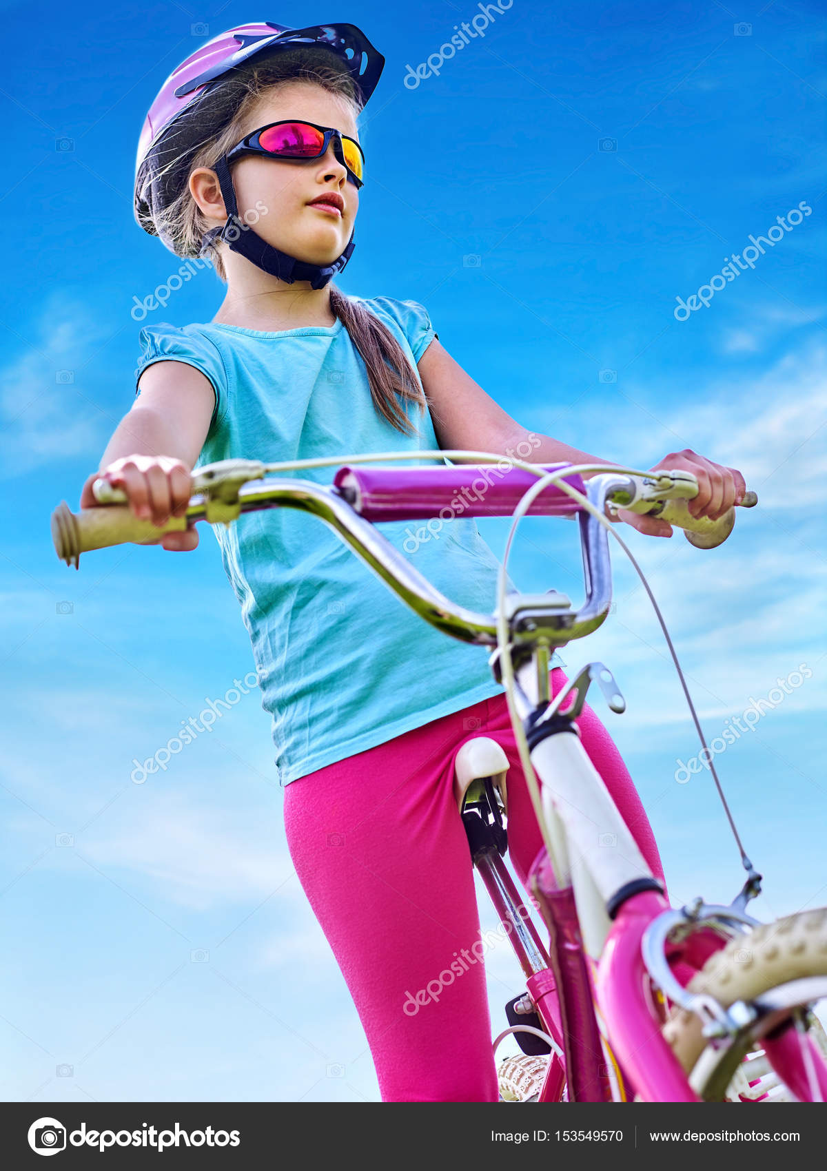 Niño viajando en bicicleta con gafas de arco iris y casco en el