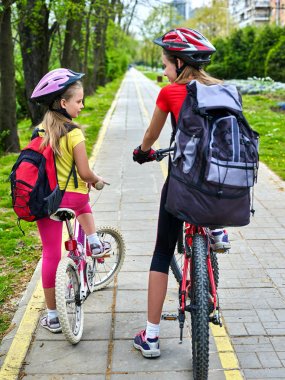 Bisiklet yolu işaret çocuklu. Sırt çantası ile kask giyen kızlar .