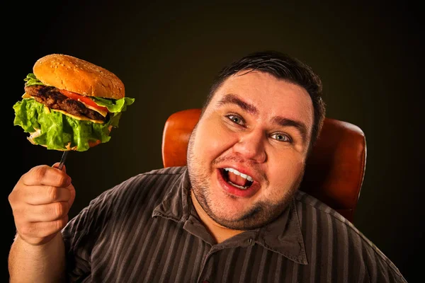 Hombre gordo comiendo hamburguesa de comida rápida. Desayuno para personas con sobrepeso . — Foto de Stock