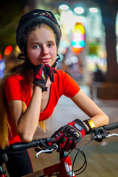 Bisiklet bisikletçi kız Bisiklet kaskı takıyor. Açık gece portresi. — Stok fotoğraf