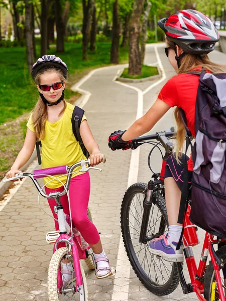 自行车道路标志与儿童。女孩子们穿着头盔带背囊 . — 图库照片