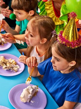 Doğum günü çocuk palyaço pasta çocukla birlikte yemeye. İle dağınık yüz çocuk.