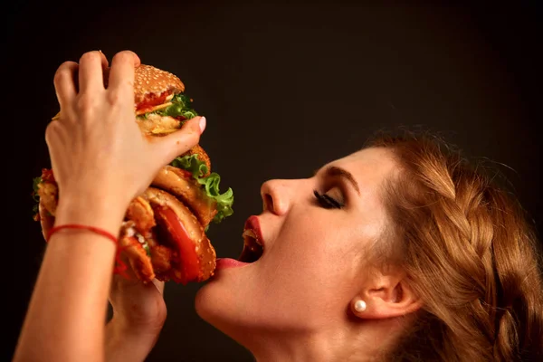 Mujer comiendo hamburguesa. Estudiante consume comida rápida . — Foto de Stock