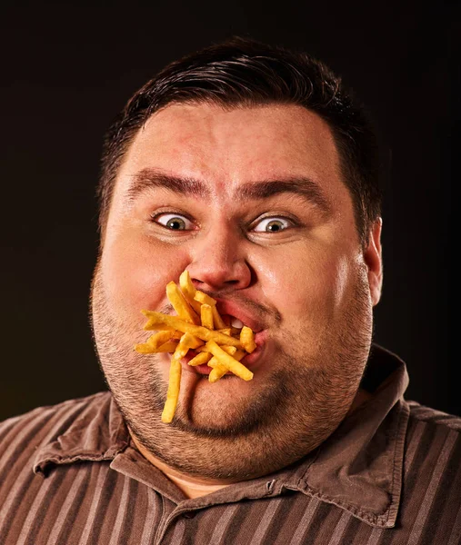 Dicker Mann isst Fast Food Pommes für Übergewichtige. — Stockfoto