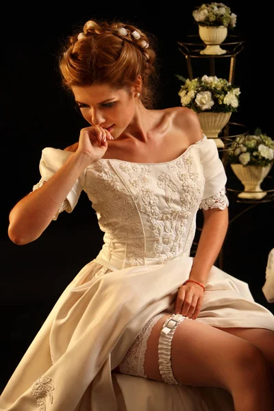 Bride puts bridal garter before wedding ceremony. — Stock Photo, Image