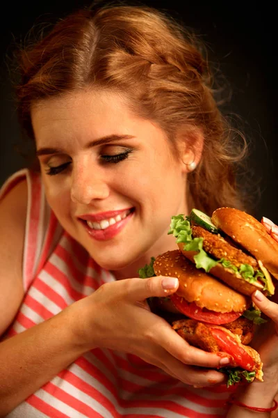 Mujer comiendo hamburguesa y guiños. Feliz estudiante comer almuerzo sándwich . — Foto de Stock