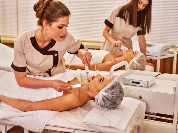 Massagem facial no salão de beleza. Estimulação elétrica casal cuidados com a pele . — Fotografia de Stock