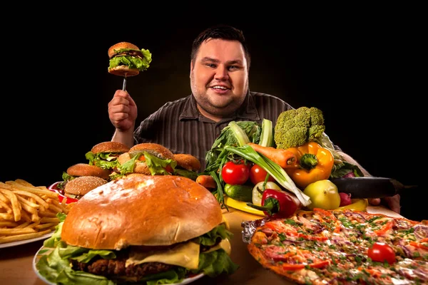 Diyet şişman adam sağlıklı ve sağlıksız gıda arasında seçim yapar. — Stok fotoğraf