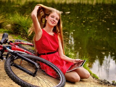 Kız Bisiklete binme bisiklet. Kız diğer bisiklet yakınındaki parka doğru vardır..