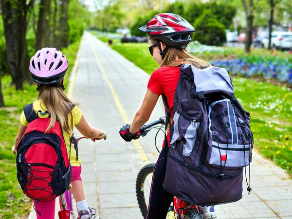 Ścieżka rowerowa z dziećmi. Dziewczyny, w hełmie z plecakiem . — Zdjęcie stockowe