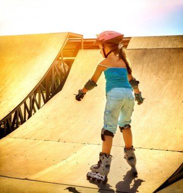 Kız paten üzerinde skatepark içinde sürme. Arka plan arkadan aydınlatmalı.