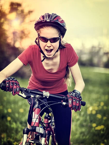 Woman traveling bicycle on green grass in summer park. — Stock Photo, Image