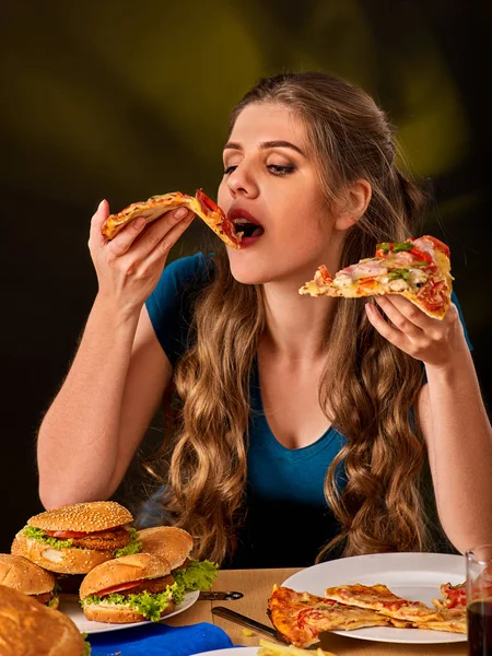 Frau isst Pommes und Hamburger mit Pizza. — Stockfoto