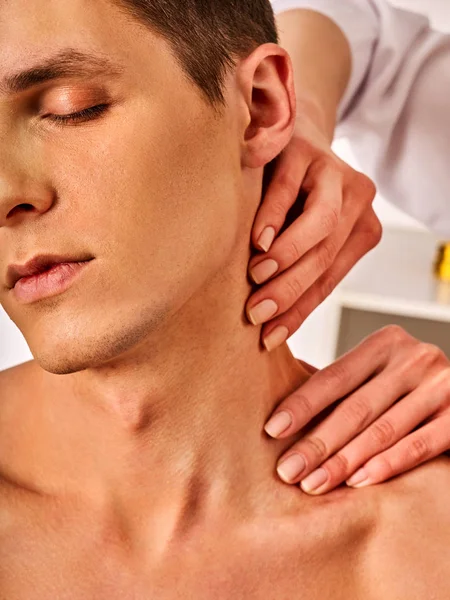 Shoulder and neck massage for man in spa salon.