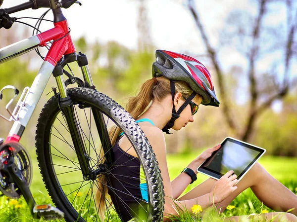 Menina passeios de bicicleta usando fone de ouvido relógio de ciclismo em tablet pc . — Fotografia de Stock