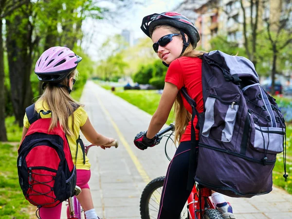 Ścieżka rowerowa z dziećmi. Dziewczyny, w hełmie z jazdy ciclyng plecak. — Zdjęcie stockowe