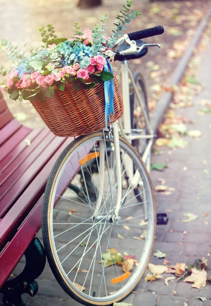 Rower z koszem kwiatów w parku w pobliżu ławce. Odcień obrazu . — Zdjęcie stockowe