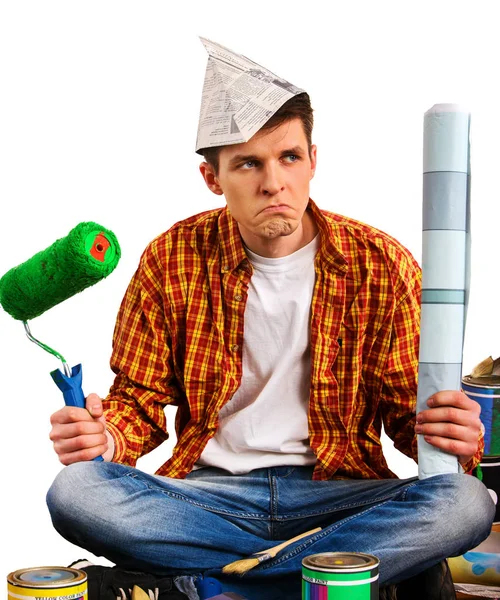 Repair home tired man in newspaper cap holding paint bank. — Stock Photo, Image